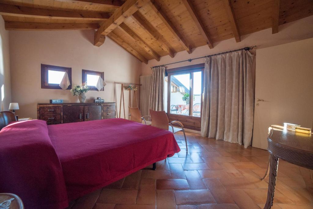 韦尔巴尼亚Romantic Nido的一间卧室设有红色的床和大窗户