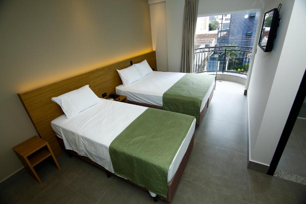 马林加NEO PARK HOTEL的带阳台的酒店客房内的两张床