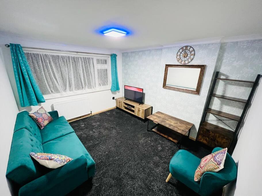 莱斯特CozyComfy Apartment Leicester的客厅配有绿色沙发和电视