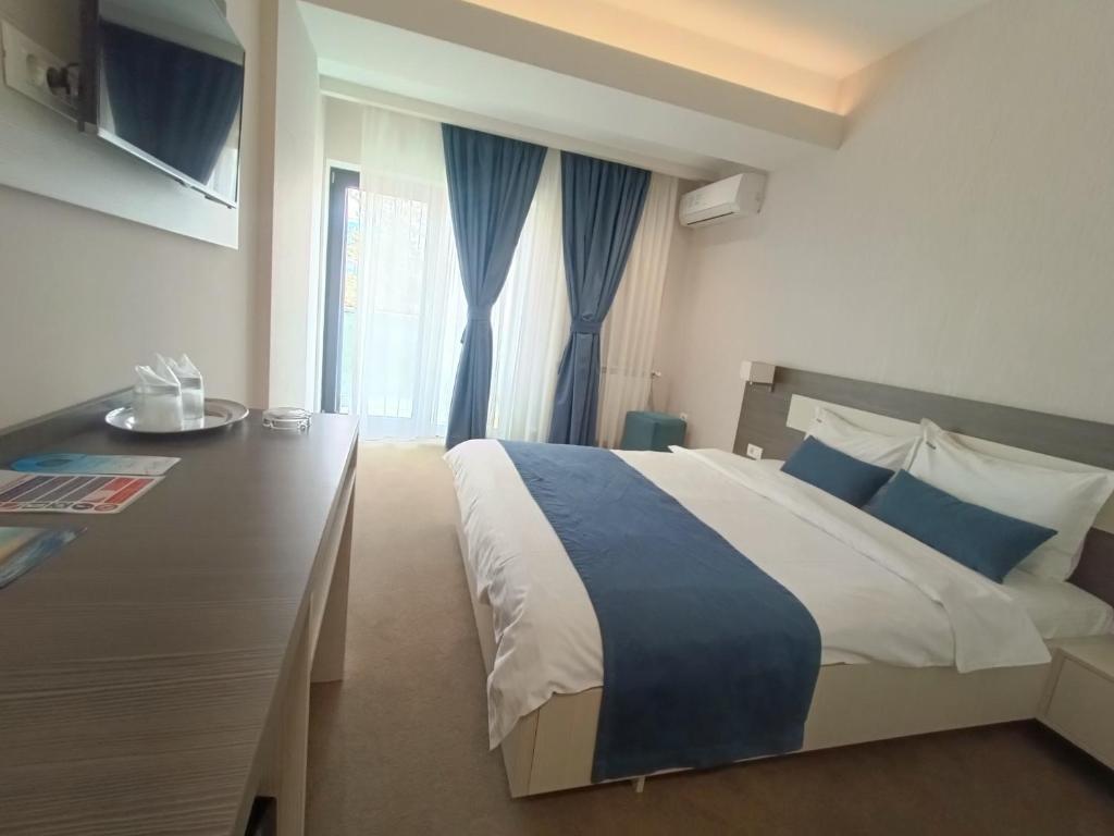 马马亚Aparthotel Mamaia的一间卧室设有一张大床和一个窗户。