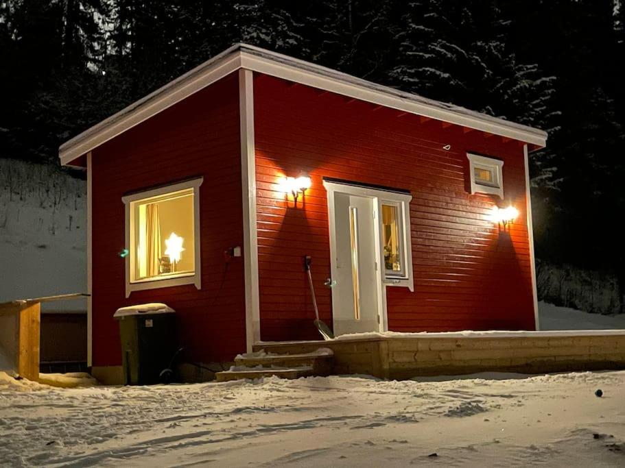 奥勒Solbergs, fint attefallshus i Vik, Åre的雪上两扇窗户的红色小房子