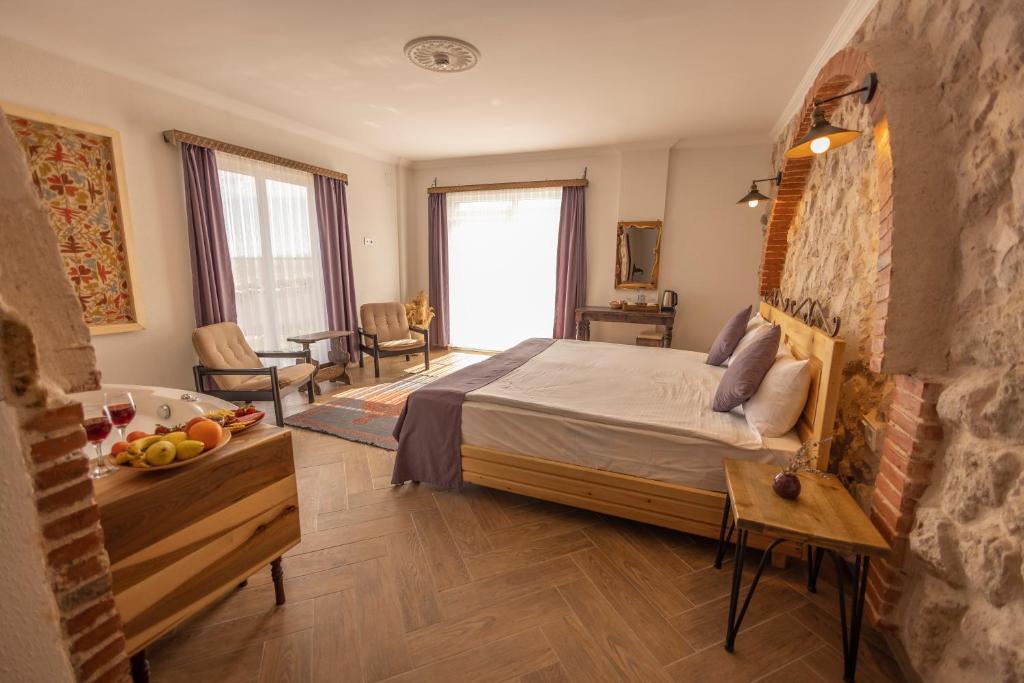 乌奇希萨尔Soleado Cappadocia Hotel的卧室配有一张床和一张带水果的桌子,位于地板上