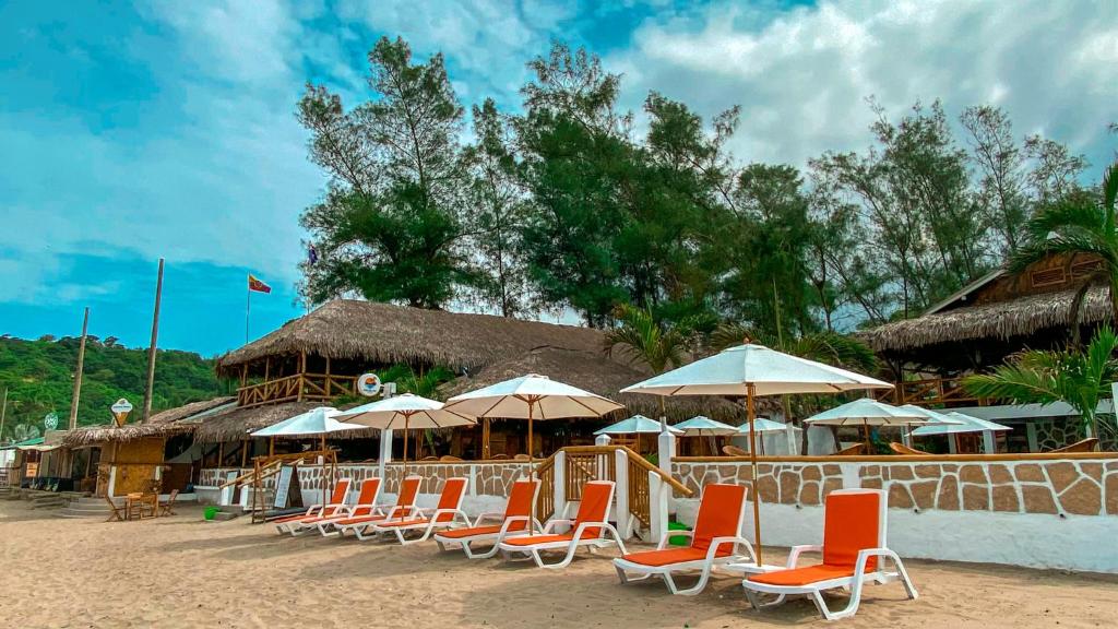 蒙塔尼塔HANGA ROA HOTEL的海滩上的一组椅子和遮阳伞