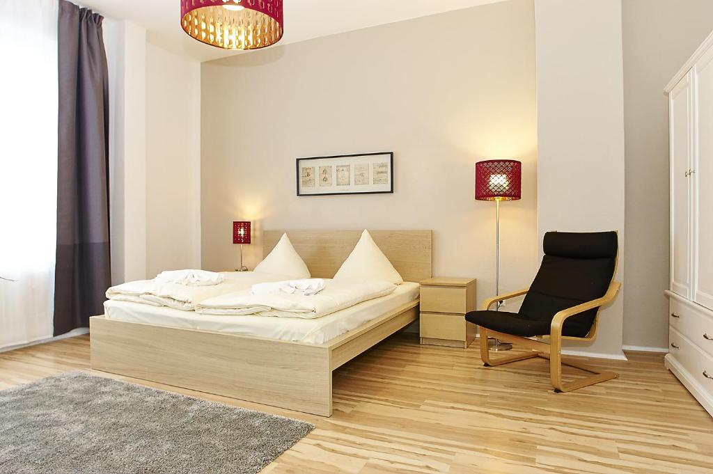柏林市中心西区比尔林城公寓的一间卧室配有一张床和一把椅子