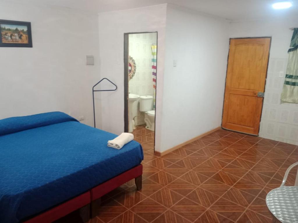 卡拉马Habitación cerca aeropuerto的一间带蓝色床的卧室和一间浴室