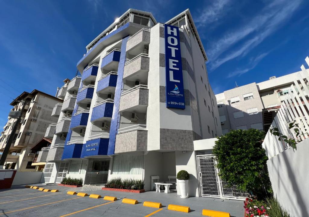 弗洛里亚诺波利斯Ilha Forte Praia Hotel的建筑的侧面有蓝色标志