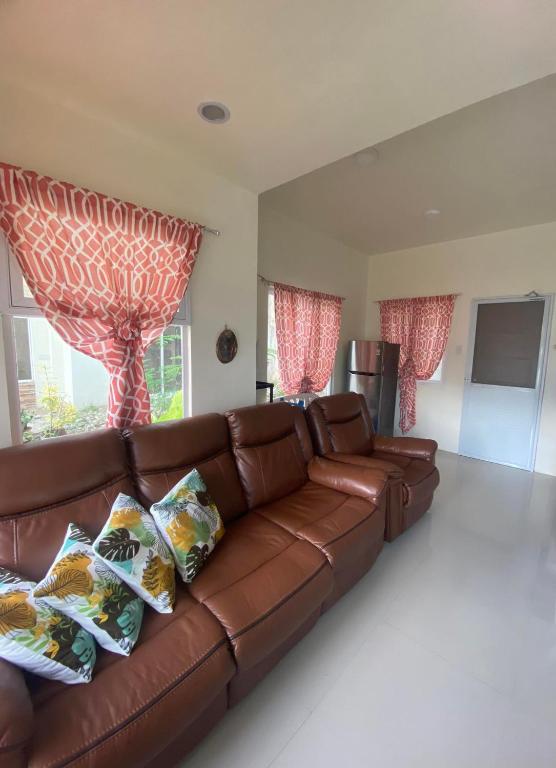 卡加盐德奥罗New 2 Bedroom Home的客厅设有窗户,配有棕色皮沙发