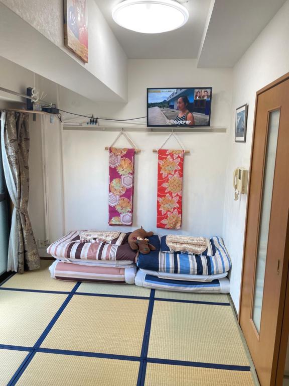 东京東洋の家-畳み部屋小庭園的一间设有两张床的客房,位于地面楼层