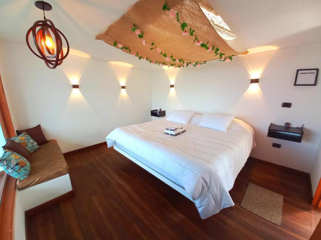 拉基拉Bajo las estrellas deluxe的一间卧室配有白色的床和灯。