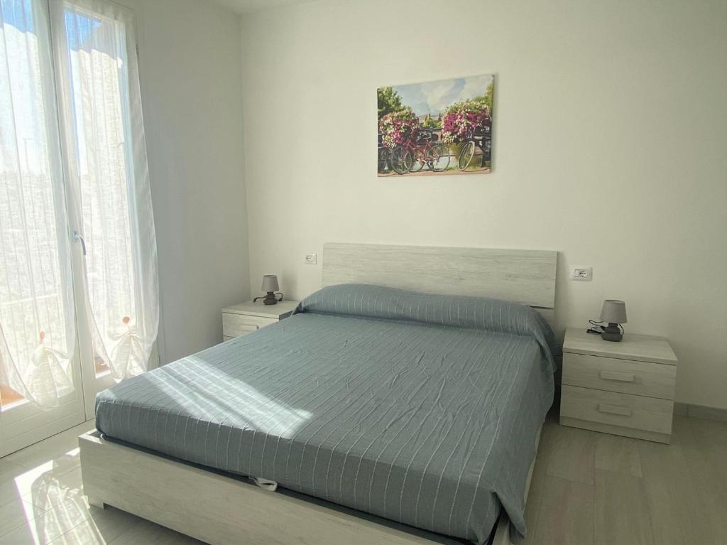 西尔米奥奈Sirmione - Independent House with Garden的卧室配有一张床,墙上挂着一幅画