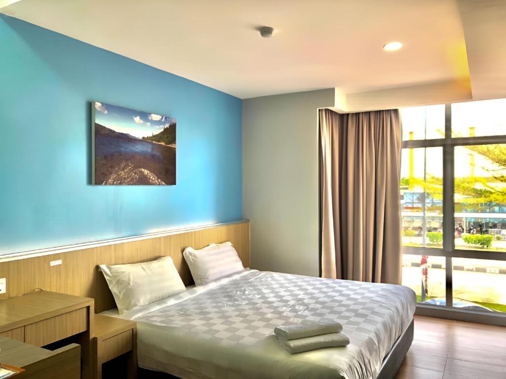 斯里曼绒双喜酒店的一间卧室配有一张蓝色墙壁的床