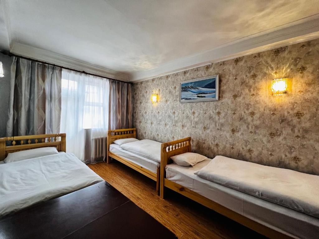 乌兰巴托Khongor Guest house & Tours的一间卧室设有两张床和窗户。
