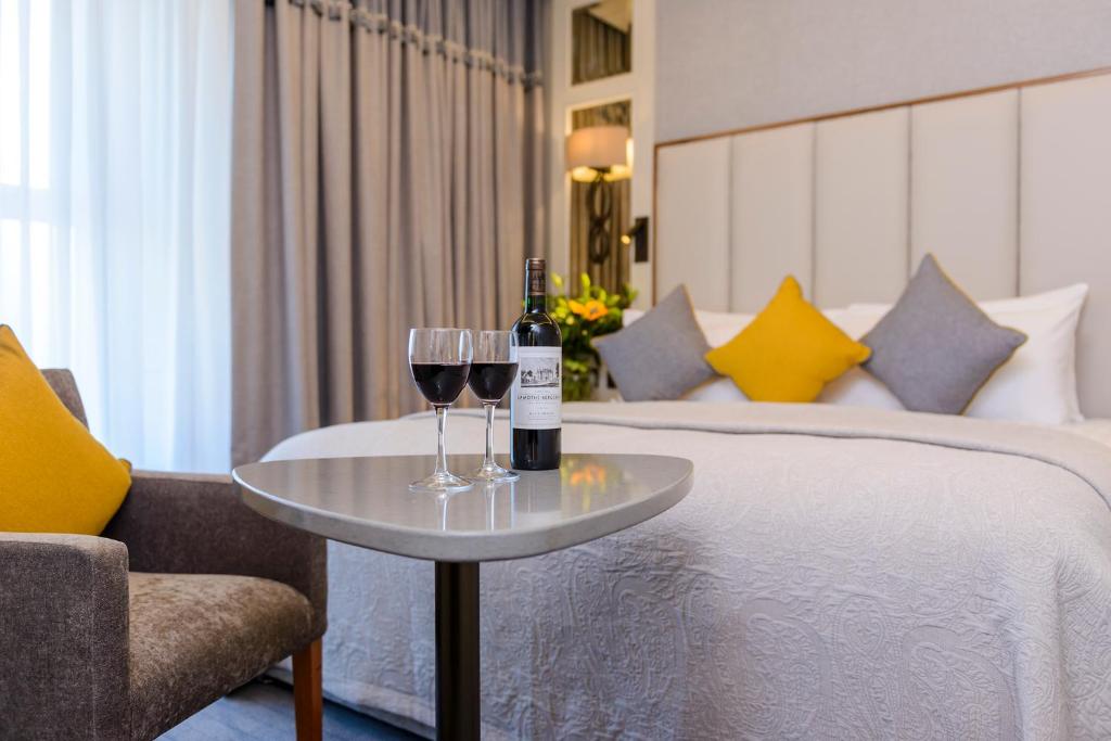 特拉利特拉利大酒店的酒店客房带一张床和两杯葡萄酒