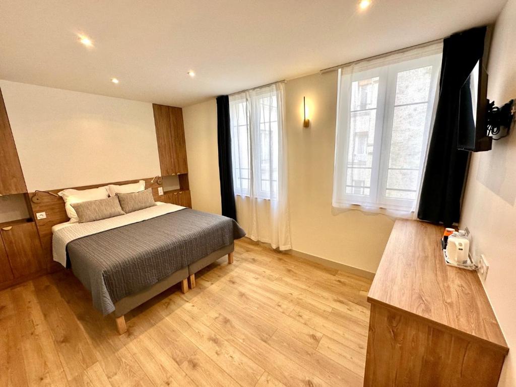巴黎佐拉酒店的一间卧室设有一张床和一个大窗户