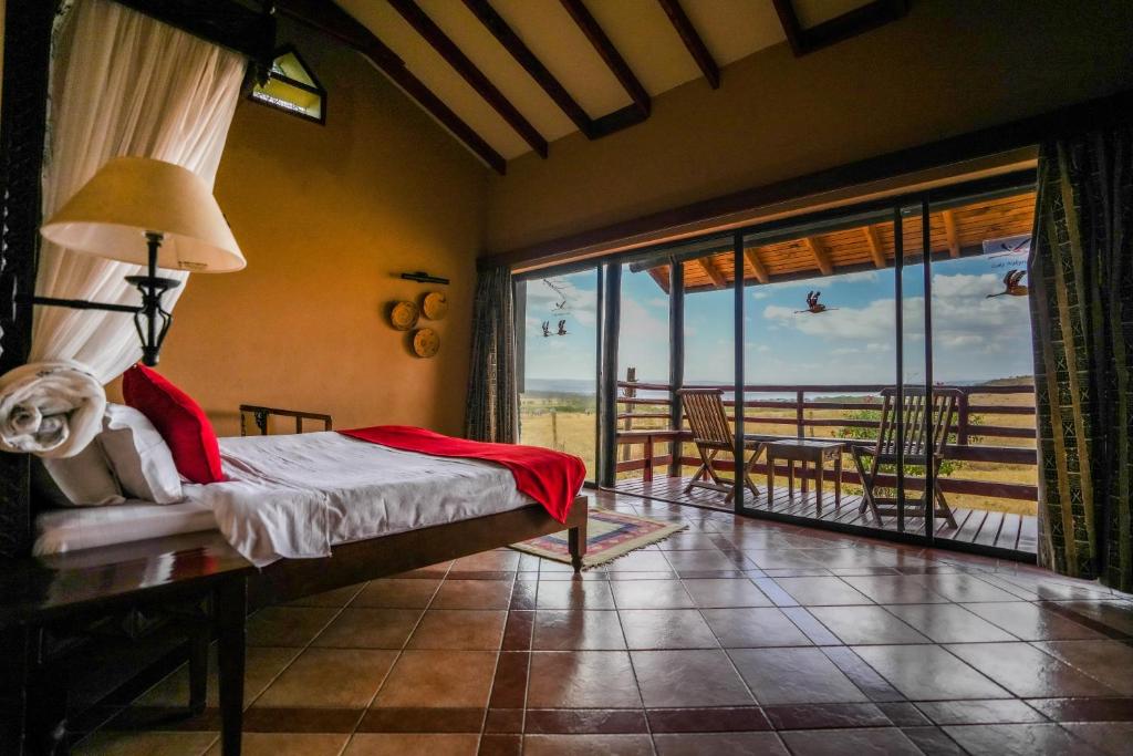 纳库鲁纳库鲁湖山林小屋的一间卧室配有一张床,享有海景