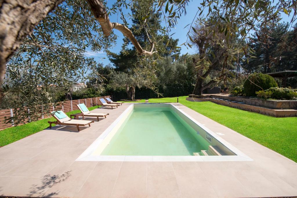 达西亚Spyrelia Villa with Private Pool & Outdoor Hot Tub的一个带长椅的庭院中间的游泳池
