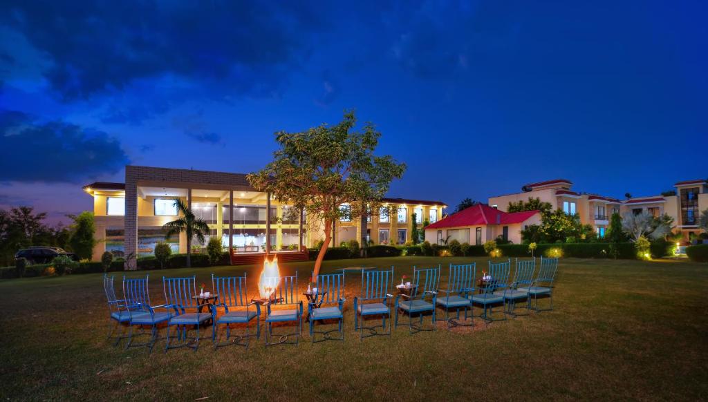 萨瓦伊马多普尔Spree Jungle Vilas Resort Ranthambore的一群椅子和一火炉在建筑物前