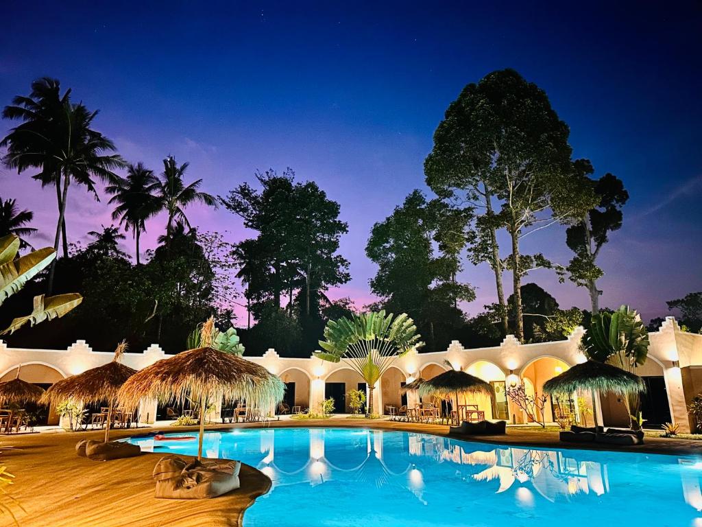 拉迈Zibá Home Suites的设有一个夜间大型游泳池的度假村