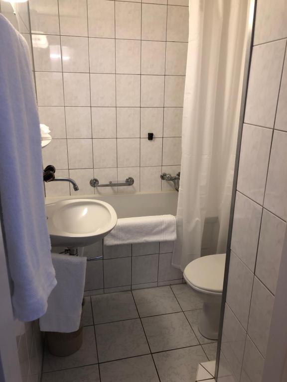 迈恩费尔德海迪豪弗酒店和餐厅的浴室配有盥洗盆、卫生间和浴缸。