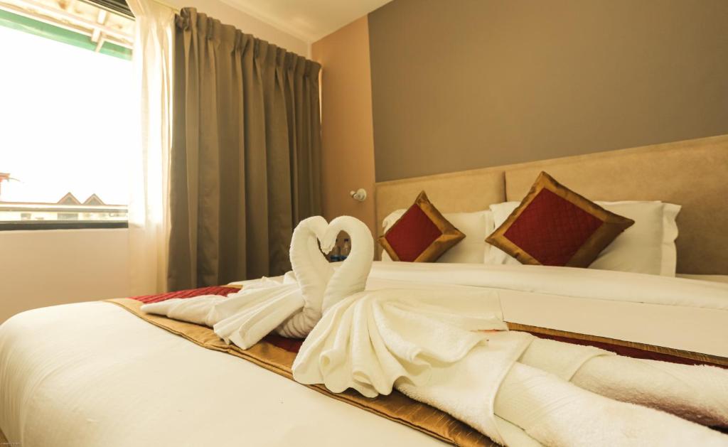 达兰萨拉Hotel Buddha's Abode的床上用毛巾制成的天鹅