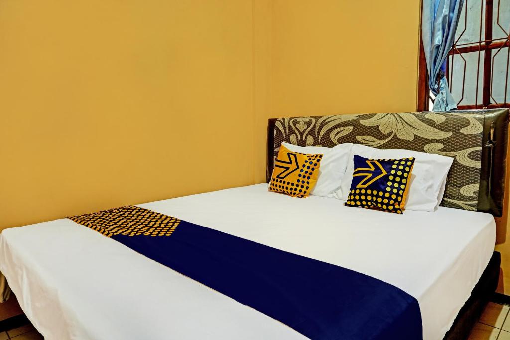 玛琅SPOT ON 92450 Homestay Simpang Panji Suroso Syariah的一张床上有两个枕头的房间