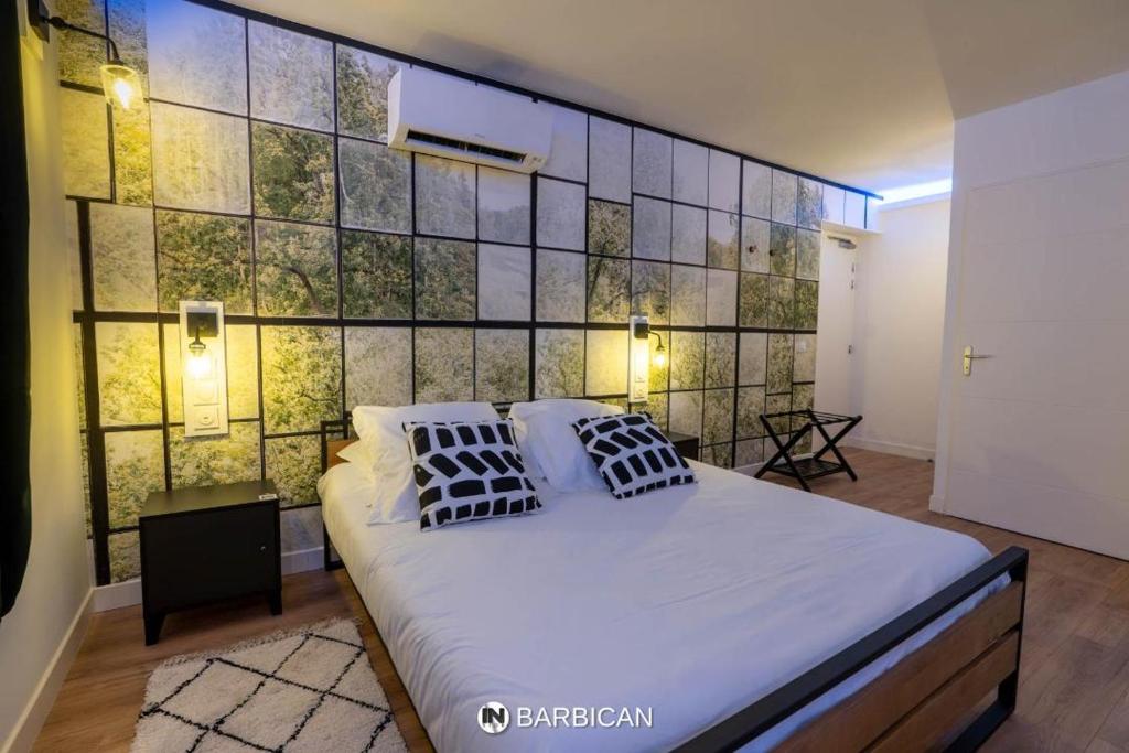 维拉尔雷东布Barbican的卧室设有一张大床和瓷砖墙
