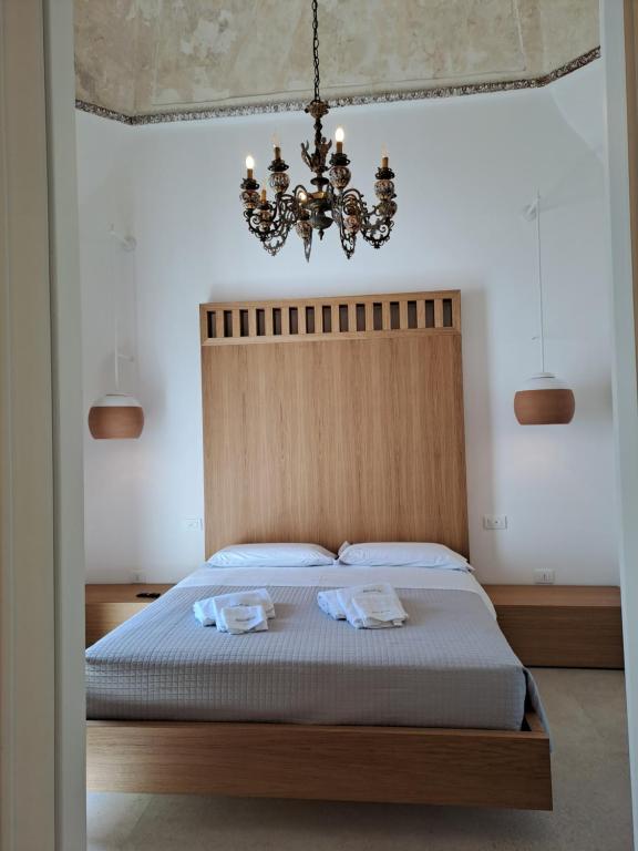 奥斯图尼Palazzo AD 1892 - SUITES & SPA的一间卧室配有一张带吊灯的床