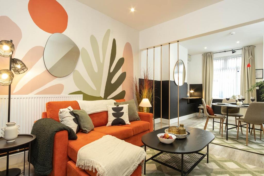 考文垂Eden House的客厅配有橙色沙发和桌子