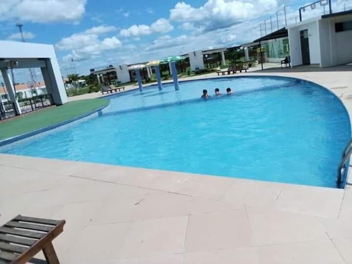 特立尼达Casa en condominio el dorado的一个大型蓝色游泳池,里面有人