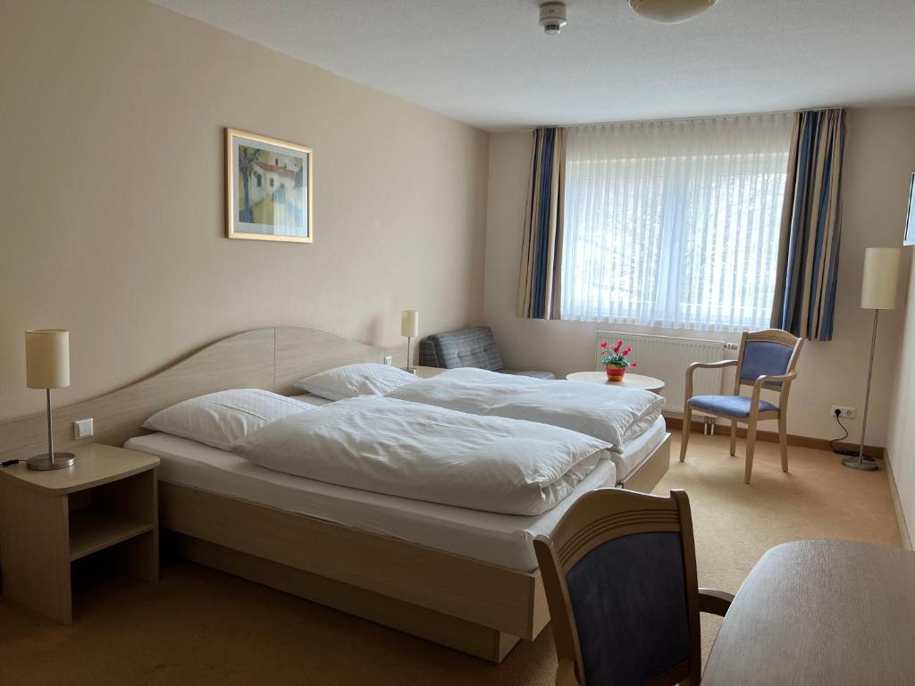 于尔岑Hotel am Stern Uelzen的卧室配有一张白色大床和一把椅子