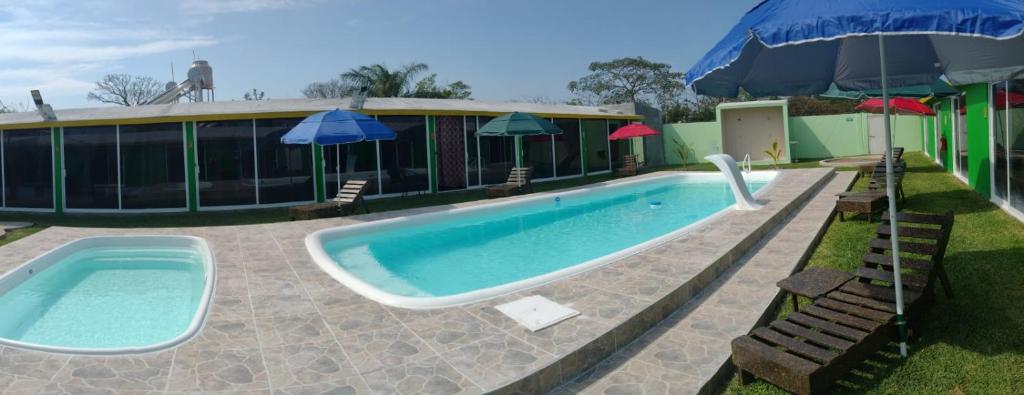 查察拉卡斯Velaria的一座带遮阳伞的游泳池位于大楼旁