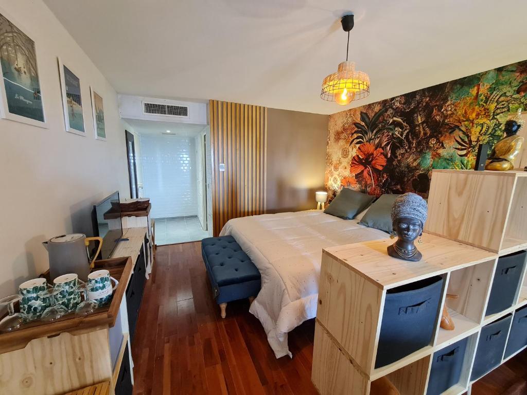圣安尼Appartement Bilimbi Guadeloupe entre Sainte-Anne et Saint-François的卧室配有一张床,墙上挂有绘画作品