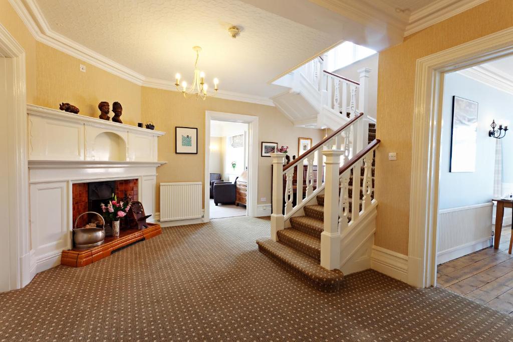 谢林汉姆Camberley House的一间带楼梯和壁炉的客厅