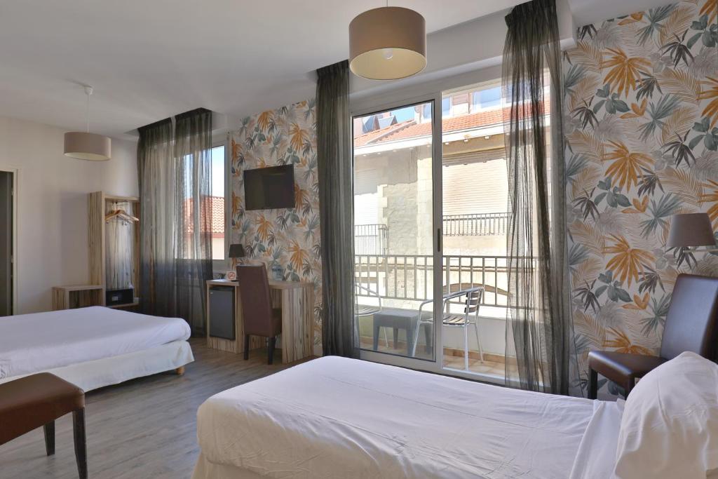 比亚里茨马贝拉布里特酒店的酒店客房设有两张床和一个阳台。