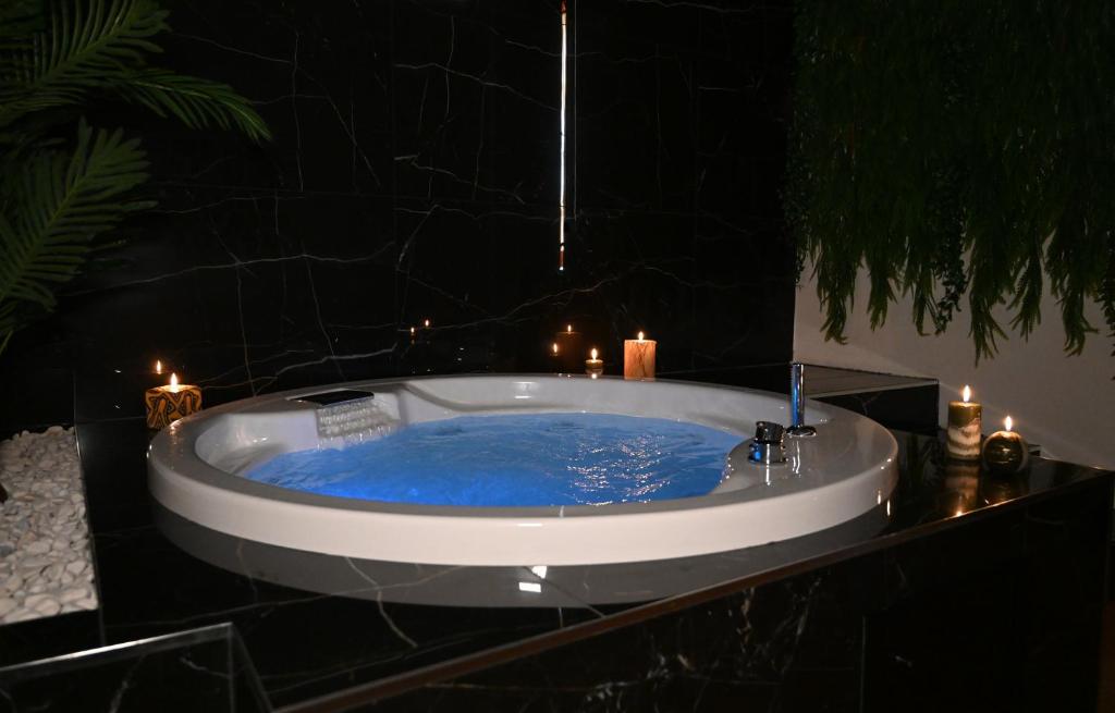 科森扎Palace Eight - Suites & Spa的配有蜡烛的客房内的蓝色浴缸