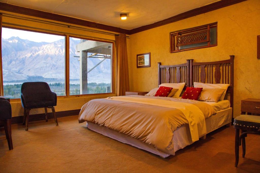 锡卡都Baltistan Fort的一间卧室设有一张大床和一个大窗户