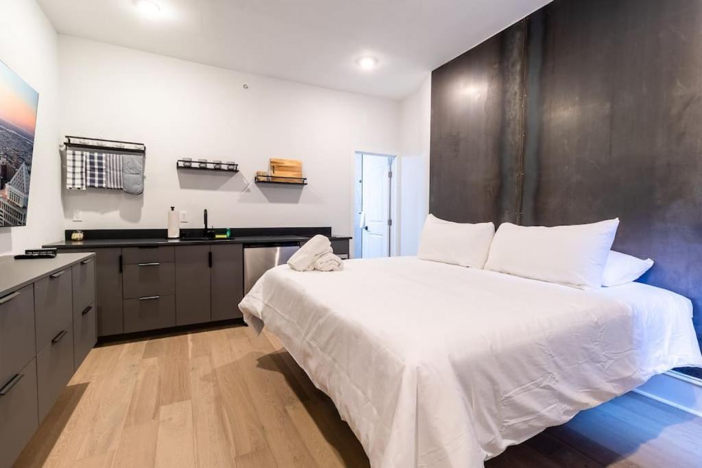 费城Thena Hotel- Lux Studio的一间带白色大床的卧室和一间厨房