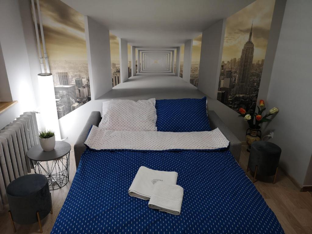 克罗斯诺Apartament przy dworcu的一间享有城市美景的卧室,配有一张蓝色的床