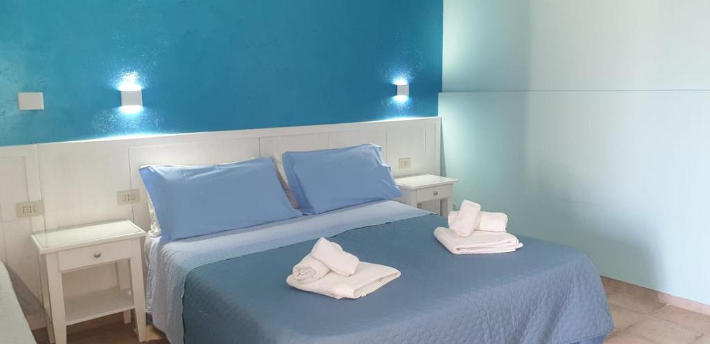 奥特朗托La Carcara的蓝色卧室,配有带毛巾的床