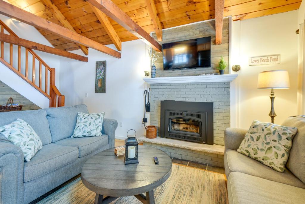 Cozy Tuftonboro Home with Deck - Walk to Beaches!的带沙发和壁炉的客厅