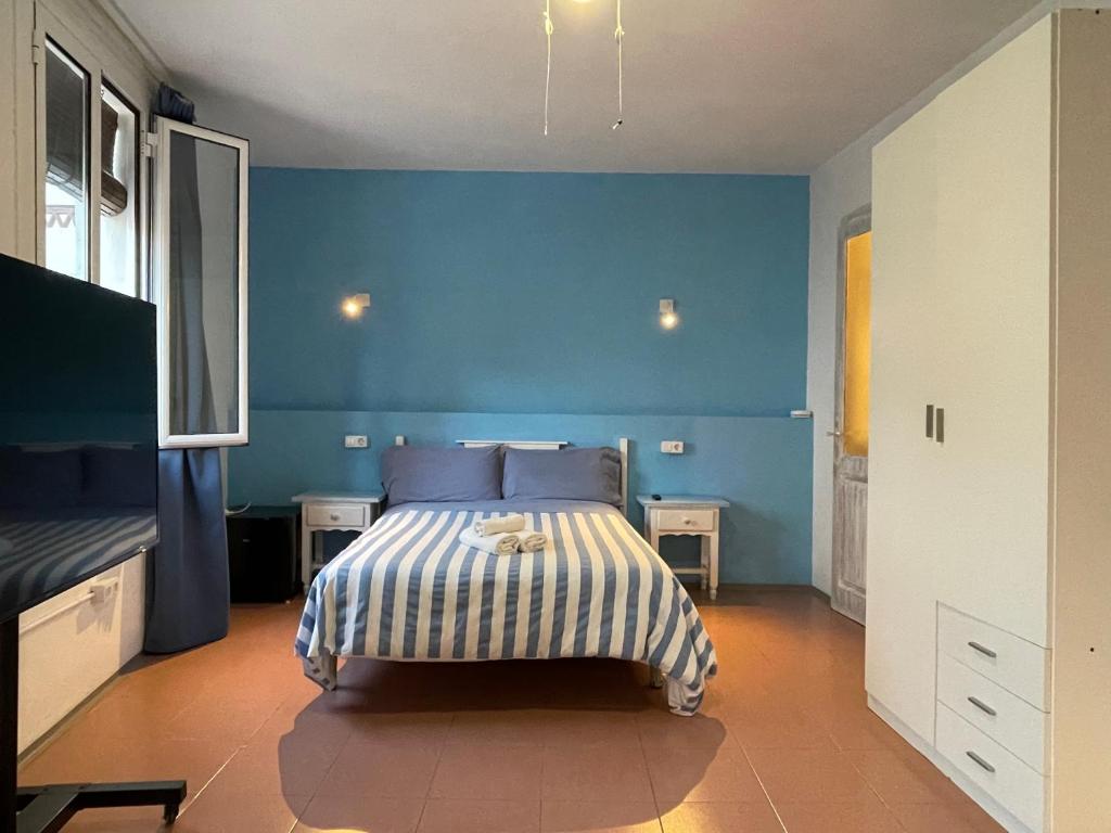 滨海托萨P&R hostals Can Tort的蓝色卧室,配有蓝色墙壁的床