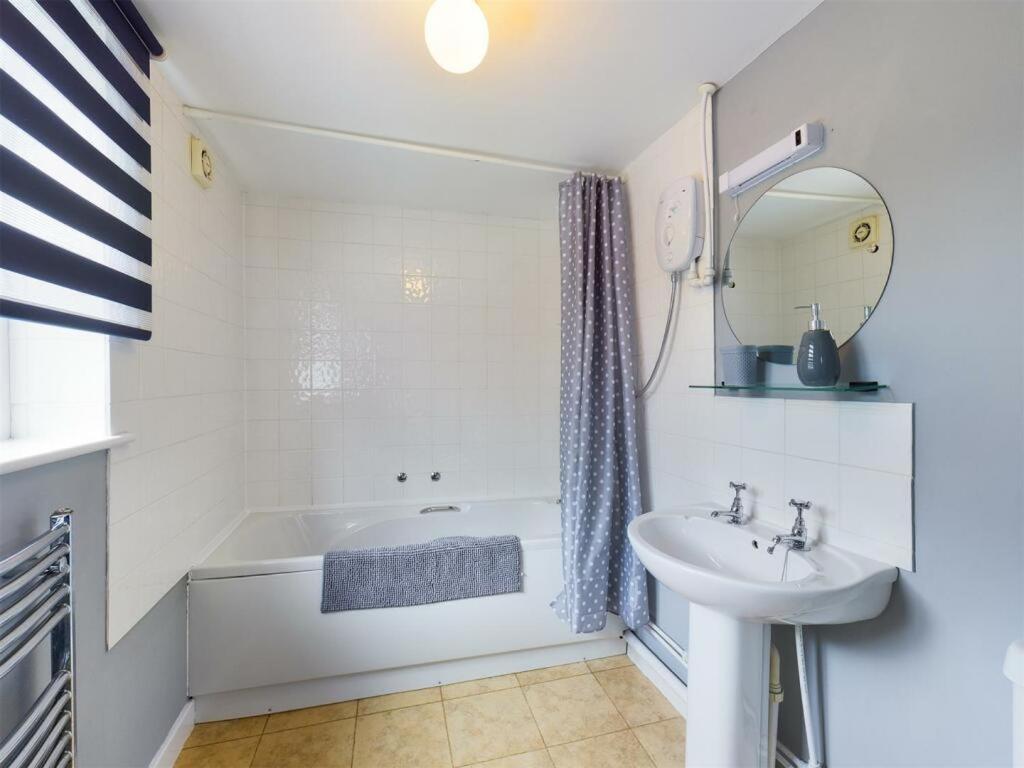 莱明斯特The Coach House at Copper Hall的白色的浴室设有浴缸和水槽。