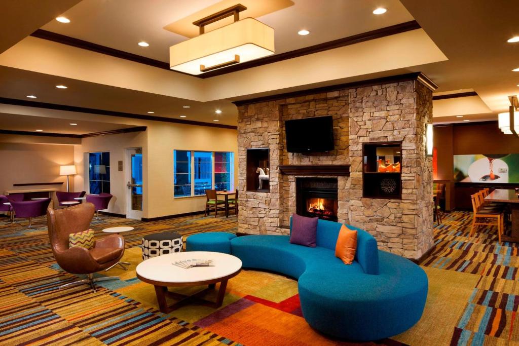 休斯顿休斯顿洲际机场费尔菲尔德客栈的客厅设有蓝色的沙发和壁炉