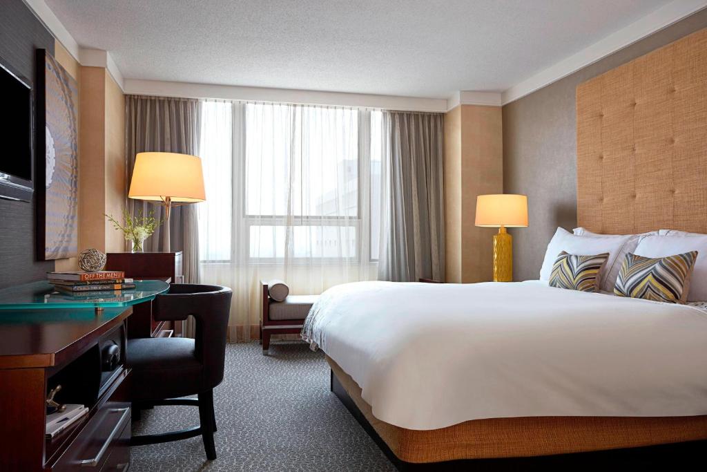 哥伦布哥伦布市中心万丽酒店的酒店客房设有一张大床和一张书桌。
