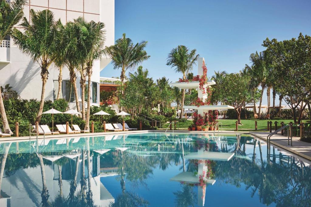 迈阿密海滩迈阿密海滨艾迪逊酒店的一座棕榈树游泳池和一座建筑