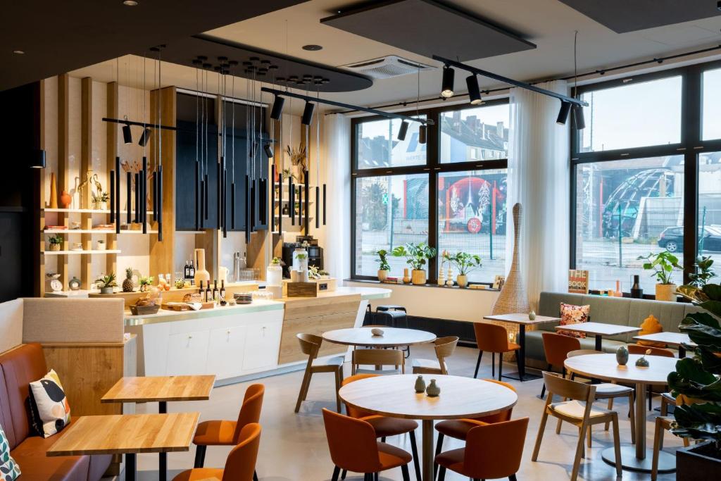 多特蒙德Residence Inn by Marriott Dortmund City的餐厅设有桌椅和大窗户。