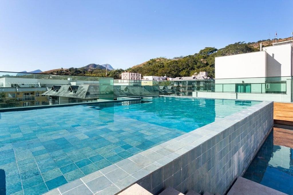 伊泰帕瓦Apto Itaipava, piscina borda infinita, montanha的建筑物屋顶上的游泳池