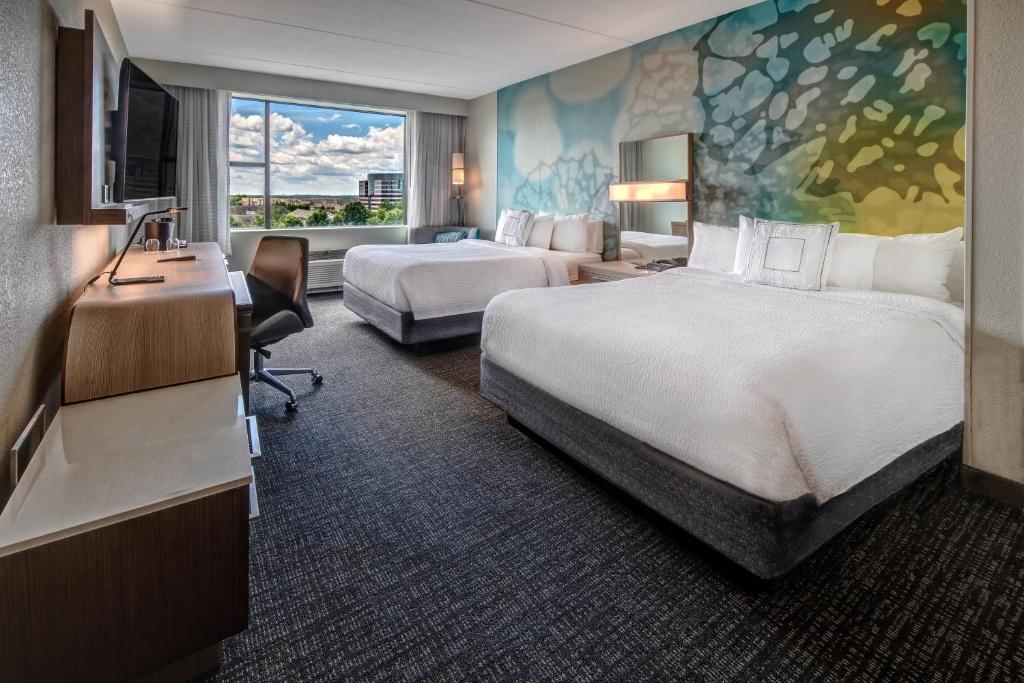 赫恩登赫恩登杜勒斯机场万怡酒店的酒店客房配有两张床和一张书桌