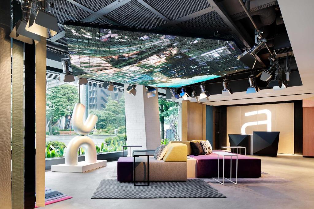 东京Aloft Tokyo Ginza的客房设有床、沙发和桌子。
