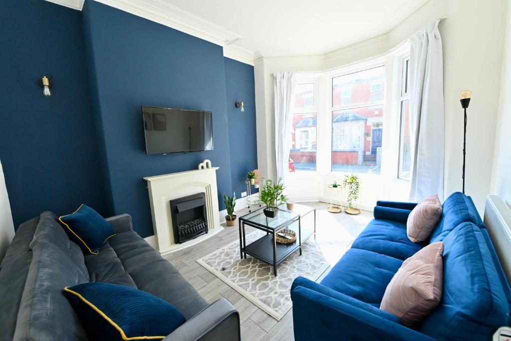 布莱克浦Manchester House的客厅拥有蓝色的墙壁和蓝色的沙发